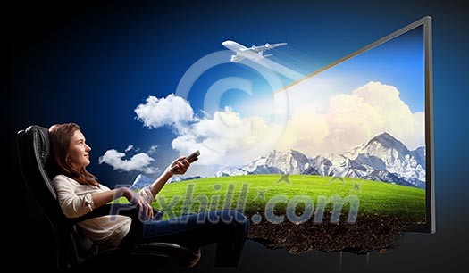 Image of young woman in armchair watching 3d tv Image of young woman in armchair watching 3d tv