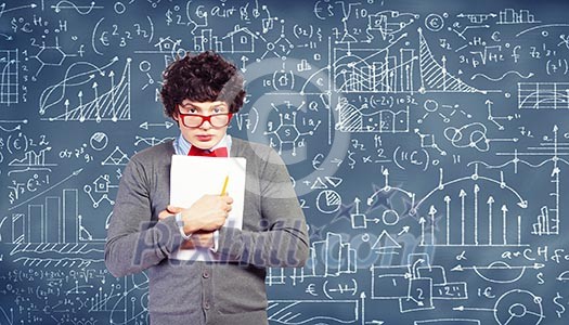 Young man in glasses standing and holding papers against blackboard Young man in glasses standing and holding papers against blackboard