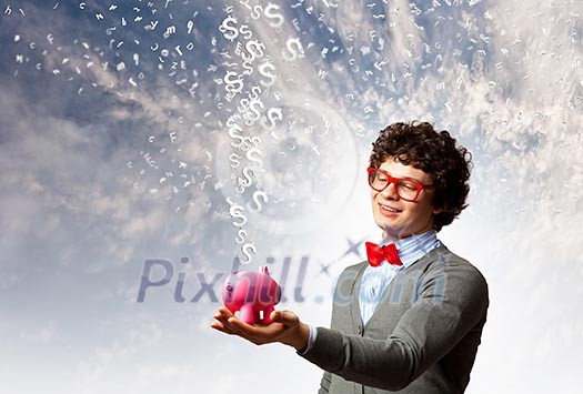 Image of young businessman in red glasses holding moneybox Image of young businessman in red glasses holding moneybox