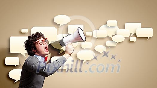 Portrait of young man shouting loudly using megaphone Portrait of young man shouting loudly using megaphone
