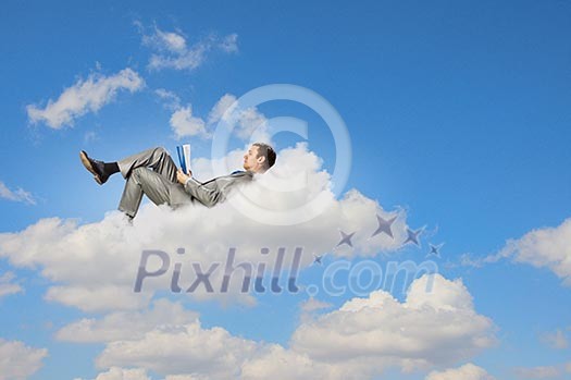 Image of businessman lying on clouds with tablet pc Image of businessman lying on clouds with tablet pc