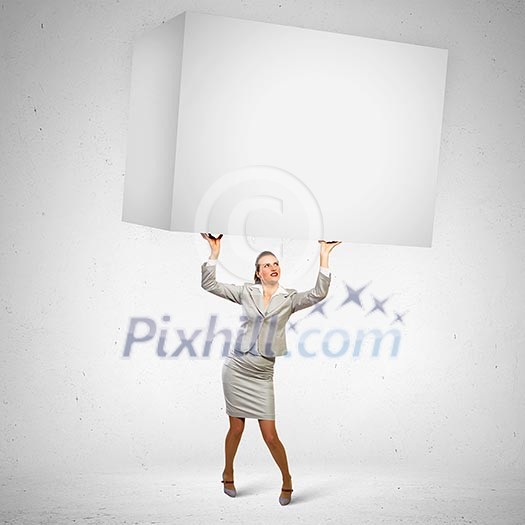 Image of business woman holding heavy white cube above head Image of business woman holding heavy white cube above head