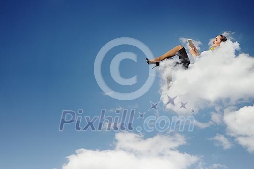 Image of businesswoman lying on clouds with tablet pc Image of businesswoman lying on clouds with tablet pc