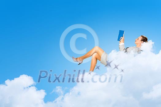 Image of businesswoman lying on clouds with book Image of businesswoman lying on clouds with book