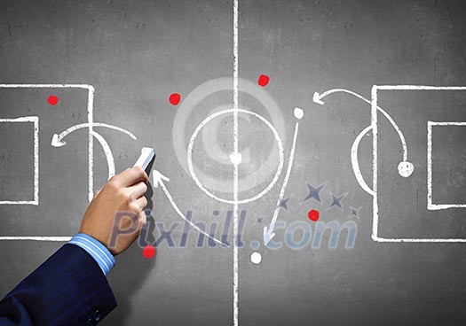 Close up image of human hand drawing football tactic plan Close up image of human hand drawing football tactic plan