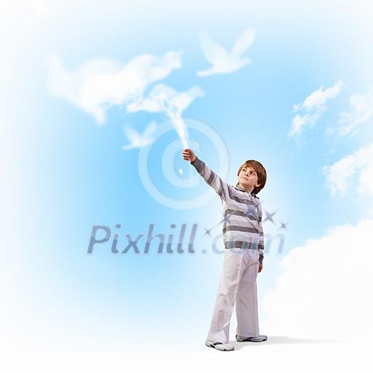 Image of little cute boy catching clouds in sky Image of little cute boy catching clouds in sky
