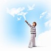Image of little cute boy catching clouds in sky