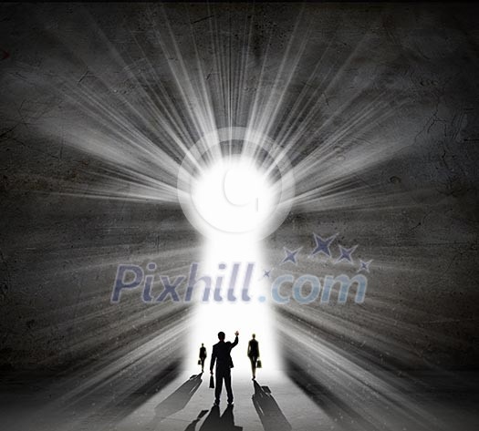 Silhouette of business people against black wall with key hole Silhouette of business people against black wall with key hole