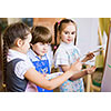 Little children painting and playing at kindergarten