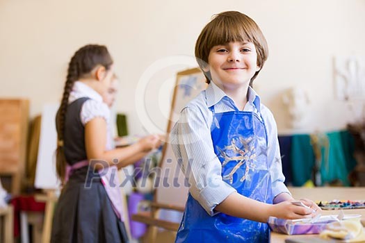 Image of little cute boy painting pictures at kindergarten Image of little cute boy painting pictures at kindergarten