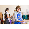 Image of little cute boy painting pictures at kindergarten