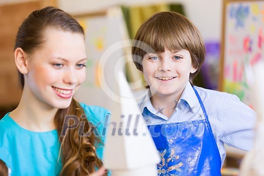 Young teacher and children painting and playing Young teacher and children painting and playing