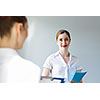 Image of young businesswoman holding folder and talking to colleague