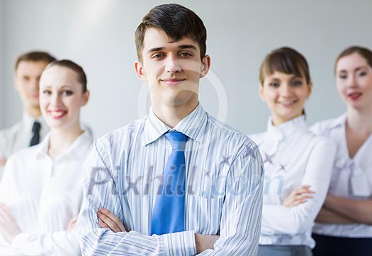 Young smiling businessman with colleagues. Leadership concept Young smiling businessman with colleagues. Leadership concept