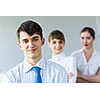 Smiling successful businessman with colleagues at background