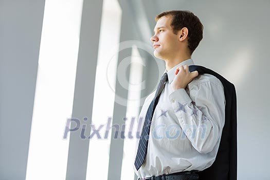 Handsome smiling businessman holding jacket on his shoulder Handsome smiling businessman holding jacket on his shoulder