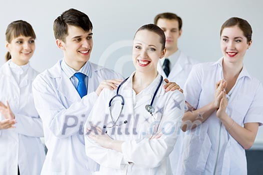 Attractive female doctor in uniform congratulated by colleagues Attractive female doctor in uniform congratulated by colleagues