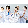 Attractive female doctor in uniform congratulated by colleagues