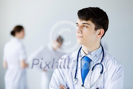 Young doctor in uniform and colleagues at background Young doctor in uniform and colleagues at background