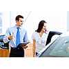 Attractive woman at car salon with consultant choosing a car