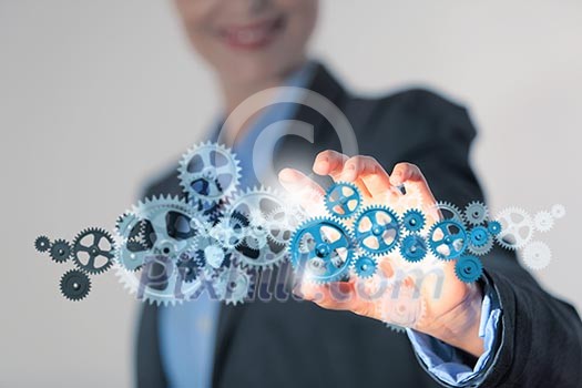 Image of businesswoman touching gear elements. Mechanism concept Image of businesswoman touching gear elements. Mechanism concept