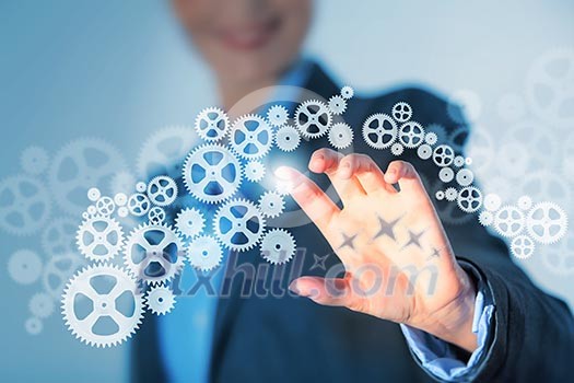 Image of businesswoman touching gear elements. Mechanism concept Image of businesswoman touching gear elements. Mechanism concept