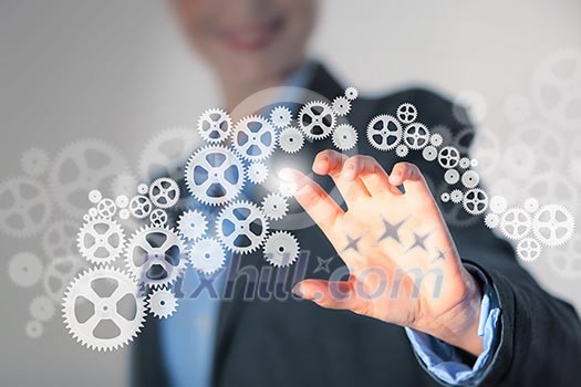 Image of businesswoman touching gear elements. Mechanism concept Image of businesswoman touching gear elements. Mechanism concept