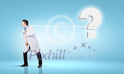 Image of male doctor pulling question sign with rope Image of male doctor pulling question sign with rope