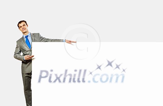Image of young man holding blank banner with crowd of business people at background Image of young man holding blank banner with crowd of business people at background
