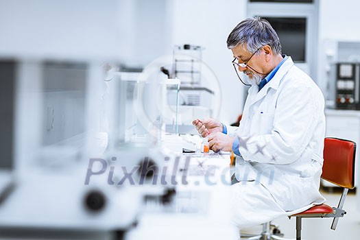 Senior male researcher carrying out scientific research in a lab (shallow DOF; color toned image)