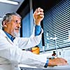 Senior male researcher carrying out scientific research in a lab (shallow DOF; color toned image)