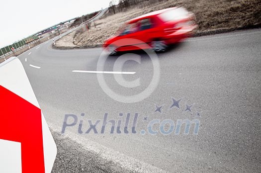 Traffic concept: car driving fast through a sharp turn (motion blur is used to convey movement) Traffic concept: car driving fast through a sharp turn (motion blur is used to convey movement)