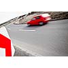 Traffic concept: car driving fast through a sharp turn (motion blur is used to convey movement)