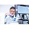 Senior male researcher carrying out scientific research in a lab (shallow DOF; color toned image)