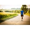 Male athlete/runner running on road - jog workout well-being concept