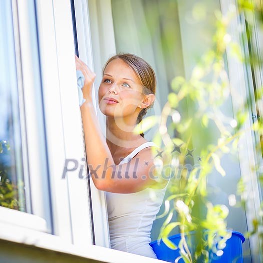 Pretty, young woman doing house work - washing windows (shallow DOF; color toned image) Pretty, young woman doing house work - washing windows (shallow DOF; color toned image)