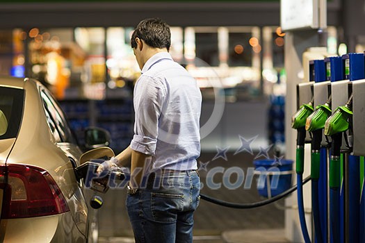 Young man fueling his car at the gas station Young man fueling his car at the gas station