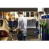 Young man fueling his car at the gas station