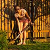 Pretty female gardener taking care of her lovely garden on a lovely spring day - cutting branches, double digging/loosening the soil with a spade