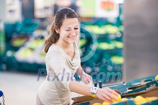 Beautiful youn woman shopping for fruits and vegetables in produce department of a grocery store/supermarket (shallow DOF; color toned image) Beautiful youn woman shopping for fruits and vegetables in produce department of a grocery store/supermarket (shallow DOF; color toned image)