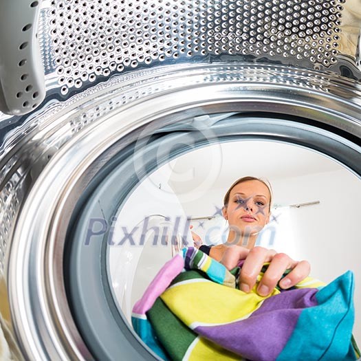 Housework: young woman doing laundry (shallow DOF; color toned image) Housework: young woman doing laundry (shallow DOF; color toned image)