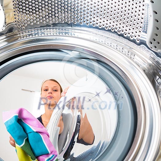 Housework: young woman doing laundry (shallow DOF; color toned image) Housework: young woman doing laundry (shallow DOF; color toned image)