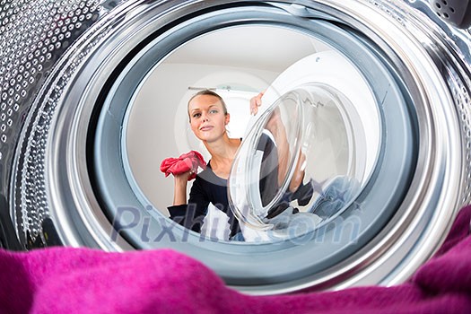 Housework: young woman doing laundry (shallow DOF; color toned image) Housework: young woman doing laundry (shallow DOF; color toned image)