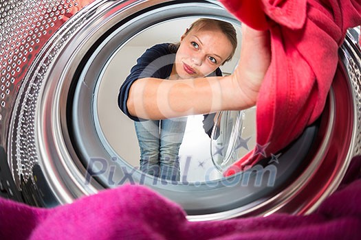 Housework: young woman doing laundry (shallow DOF; color toned image) Housework: young woman doing laundry (shallow DOF; color toned image)