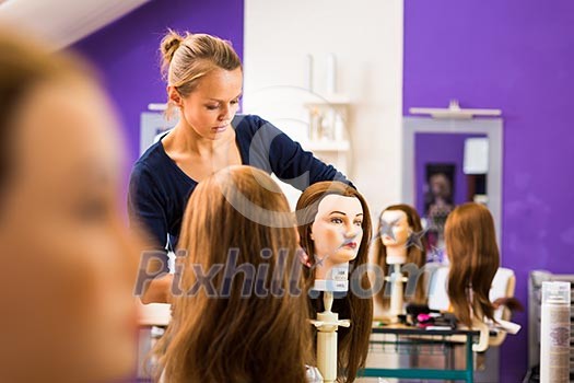 Pretty female hairdresser/haidressing apprentice/student training on an apprentice head Pretty female hairdresser/haidressing apprentice/student training on an apprentice head