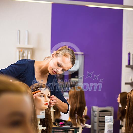 Pretty female hairdresser/haidressing apprentice/student training on an apprentice head Pretty female hairdresser/haidressing apprentice/student training on an apprentice head