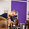 Pretty female hairdresser/haidressing apprentice/student training on an apprentice head