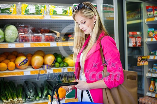 Beautiful young woman shopping for fruits and vegetables in produce department of a grocery store/supermarket (color toned image) Beautiful young woman shopping for fruits and vegetables in produce department of a grocery store/supermarket (color toned image)