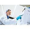 Senior male researcher carrying out scientific research in a lab (shallow DOF; color toned image)