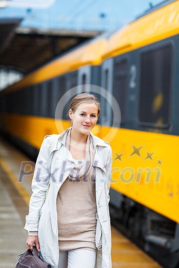 Pretty young woman at a train station (color toned image) Pretty young woman at a train station (color toned image)